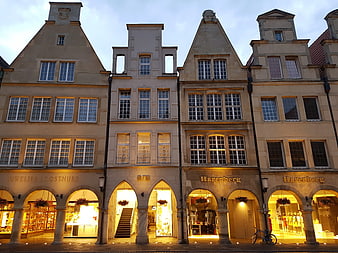 Historic European Architecture with Illuminated Shop Windows at Dusk