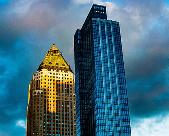 Golden and Blue Skyscrapers Against Dramatic Cloudy Sky