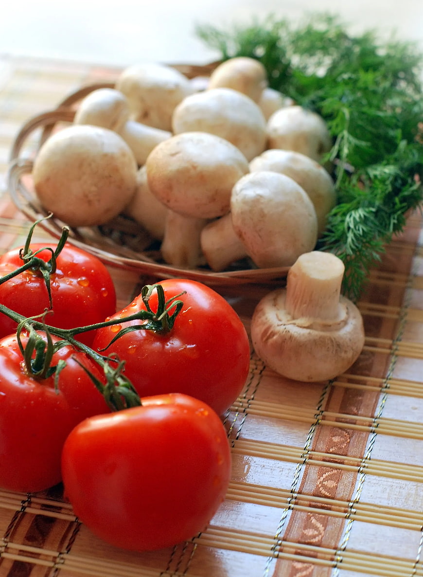Fresh Red Tomatoes and White Mushrooms on Bamboo Mat