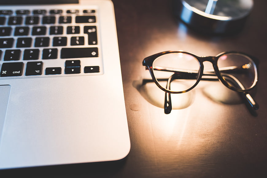 Laptop and Glasses on Wooden Desk