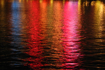 Colorful Neon Light Reflections on Rippling Water at Night