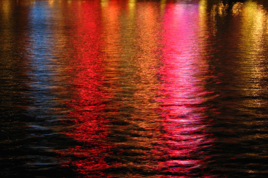 Colorful Neon Light Reflections on Rippling Water at Night