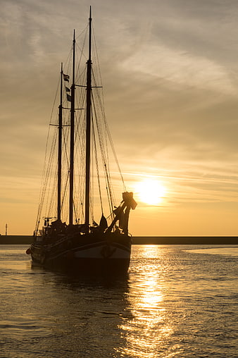 Silhouette of Three-Masted Schooner at Golden Sunset