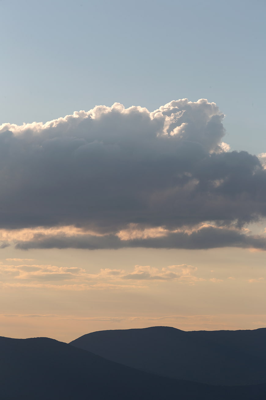 Dramatic Clouds Over Silhouetted Mountains at Sunset