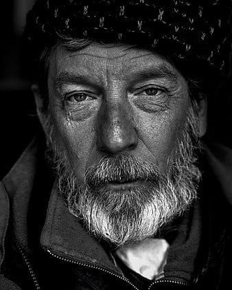 Black and white portrait of elderly homeless man with beard