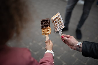Mother and child holding waffle ice cream treats outdoors