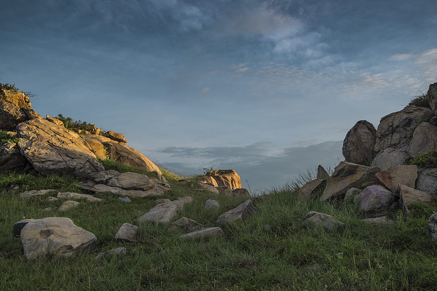 Rocky Hillside Landscape With Dramatic Cloudy Sky At Dusk