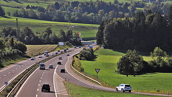 Highway Traffic Through Green Countryside Landscape