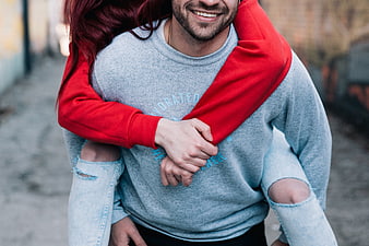 Happy couple piggyback ride in urban alley