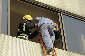 Firefighter Assisting Patient in Striped Pajamas Down Ladder