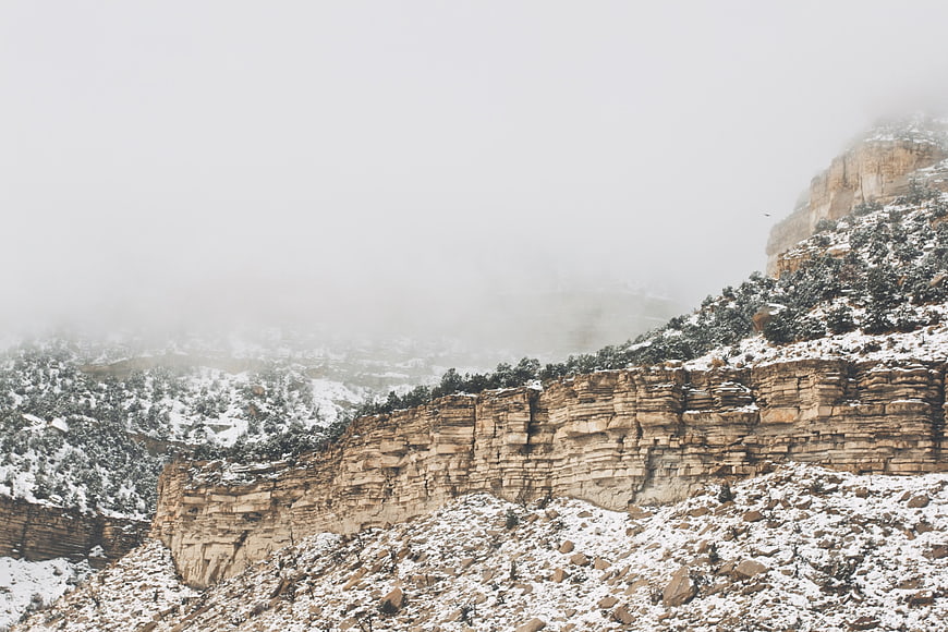 Snowy mountain cliffs shrouded in thick winter fog