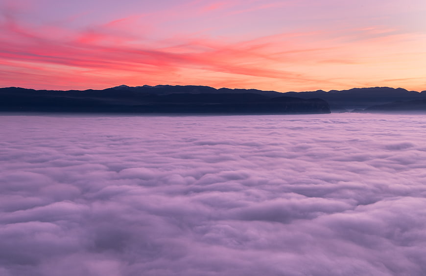 Vibrant Pink and Purple Sunset Over Sea of Clouds