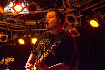 Male musician singing and playing guitar on stage