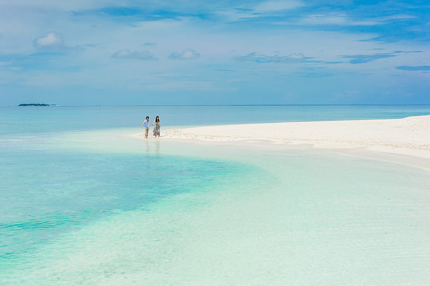 Couple Walking On White Sandbar In Turquoise Maldives Lagoon