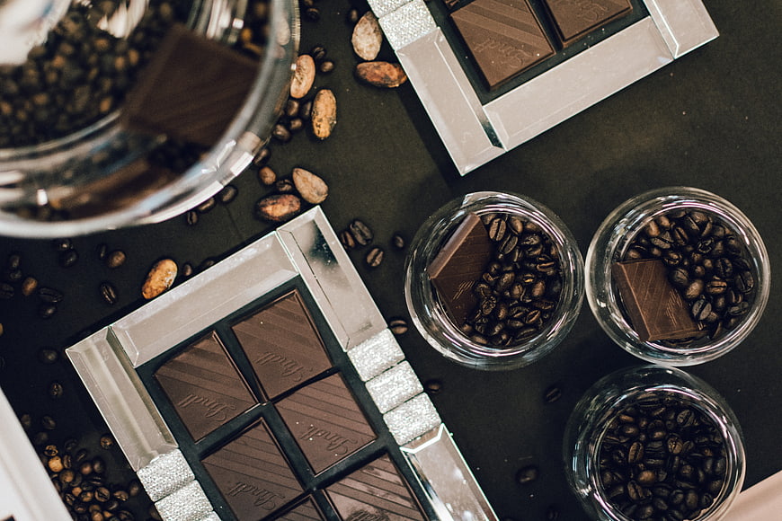 Top view of dark chocolate bars and roasted coffee beans