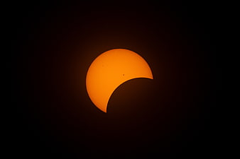 Partial Solar Eclipse with Sunspots Against Black Sky