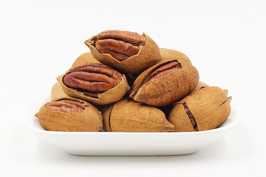 Pecans in Shells on White Bowl Isolated Background