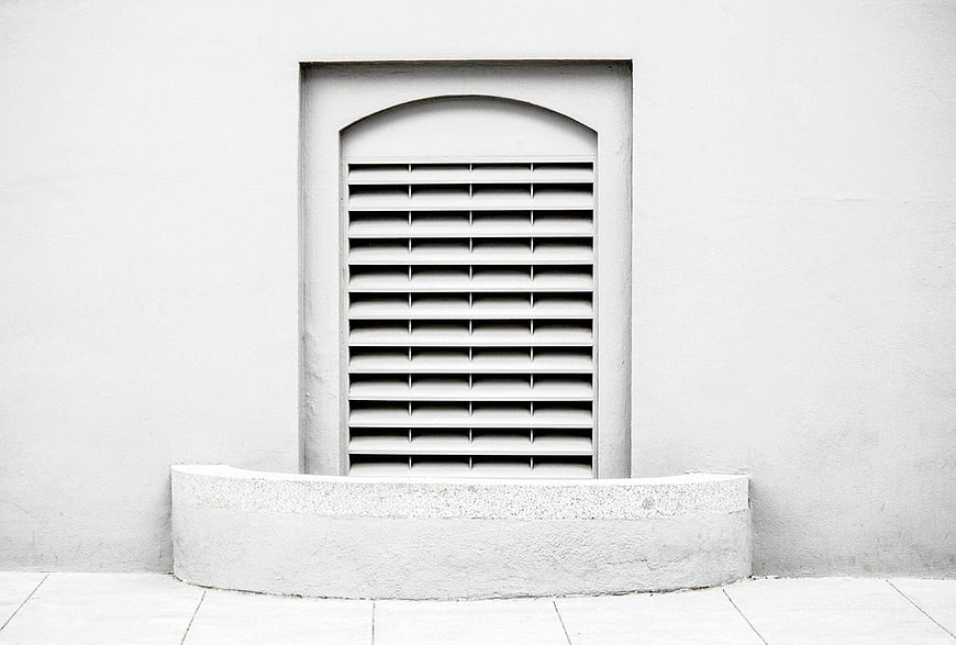 Minimalist White Window with Louvers on Textured Wall