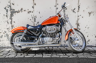 Orange Custom Chopper Motorcycle Parked on Cobblestone