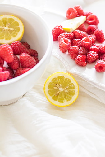 Fresh Raspberries and Lemon Slices on White Linen