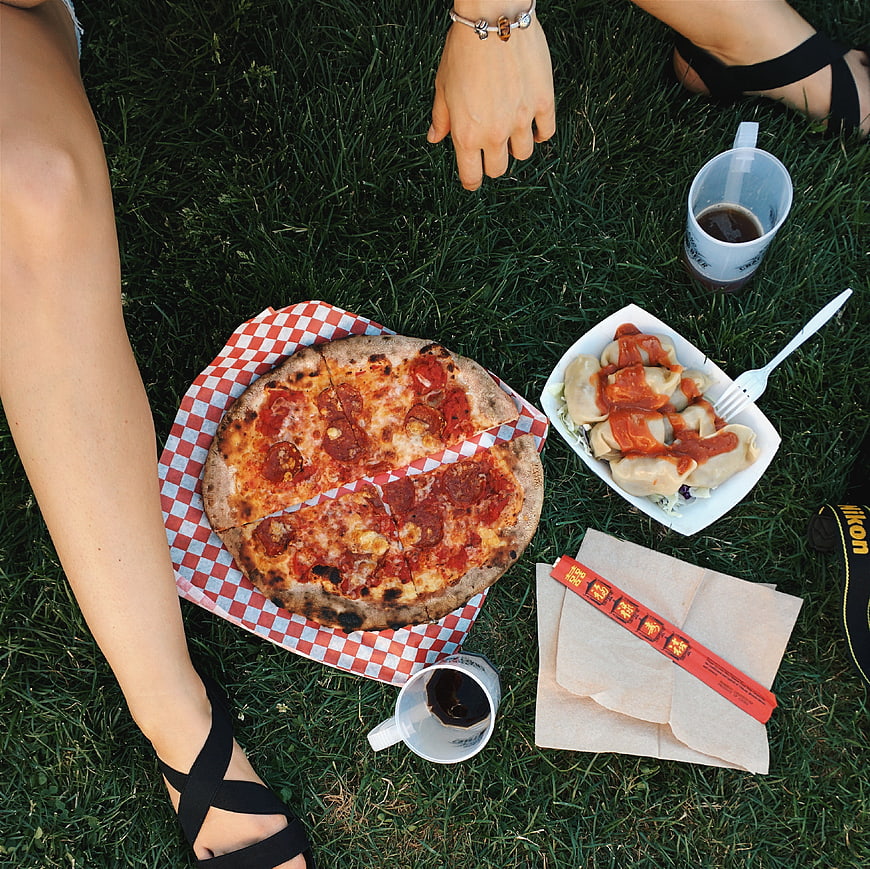 Top view of pizza and dumplings picnic on grass