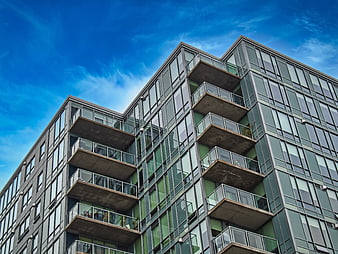 Modern Apartment Building with Balconies Against Blue Sky