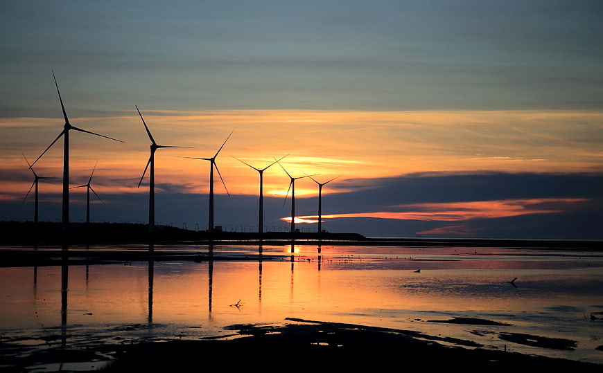 Wind Turbine Silhouettes Reflected in Water at Sunset