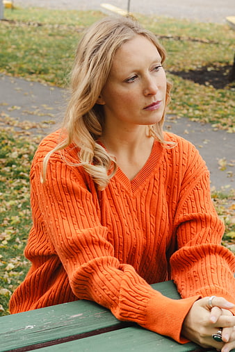 Woman in Orange Sweater Sitting on Park Bench in Autumn