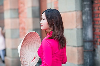 Asian Woman in Pink Ao Dai Holding Conical Hat