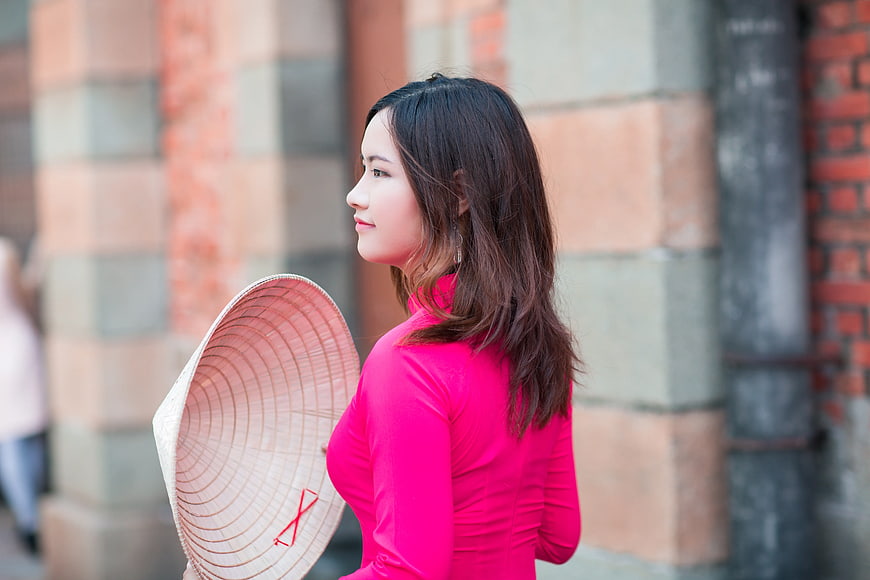 Asian Woman in Pink Ao Dai Holding Conical Hat