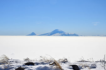 Snowy mountain peaks rising above a sea of clouds
