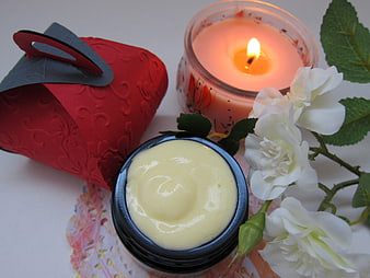 Natural skincare cream with white roses and candle