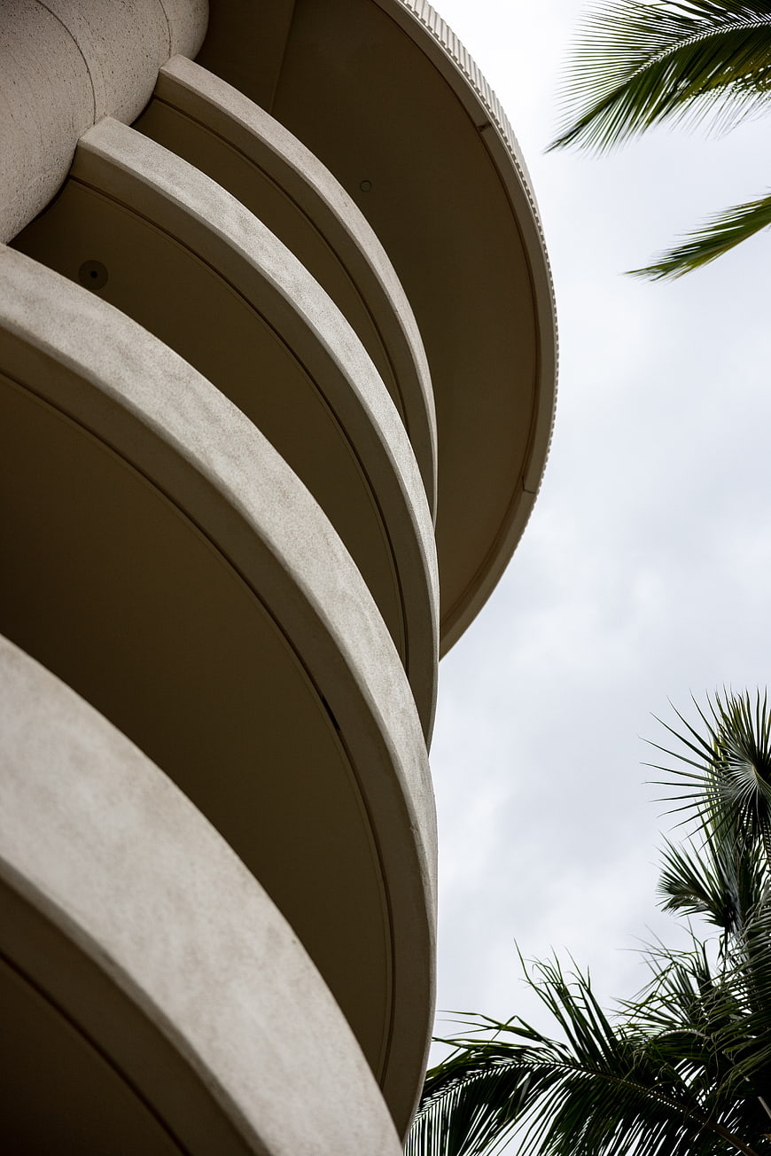 Low Angle View of Curved Modern Architecture with Palm Trees