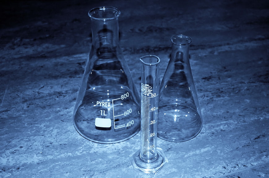 Pyrex Erlenmeyer Flasks and Graduated Cylinder on Textured Surface