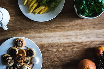 Top view of assorted pastries, fruit, and tea on a wooden table
