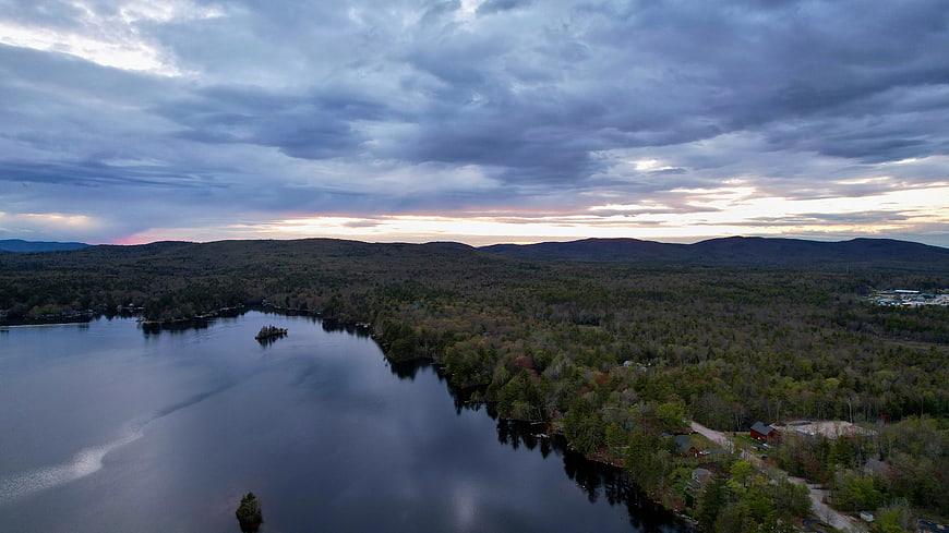 Aerial View of Lake and Forest at Dusk with Dramatic Clouds
