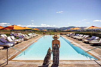 Woman and Dog Relaxing by Luxury Resort Pool