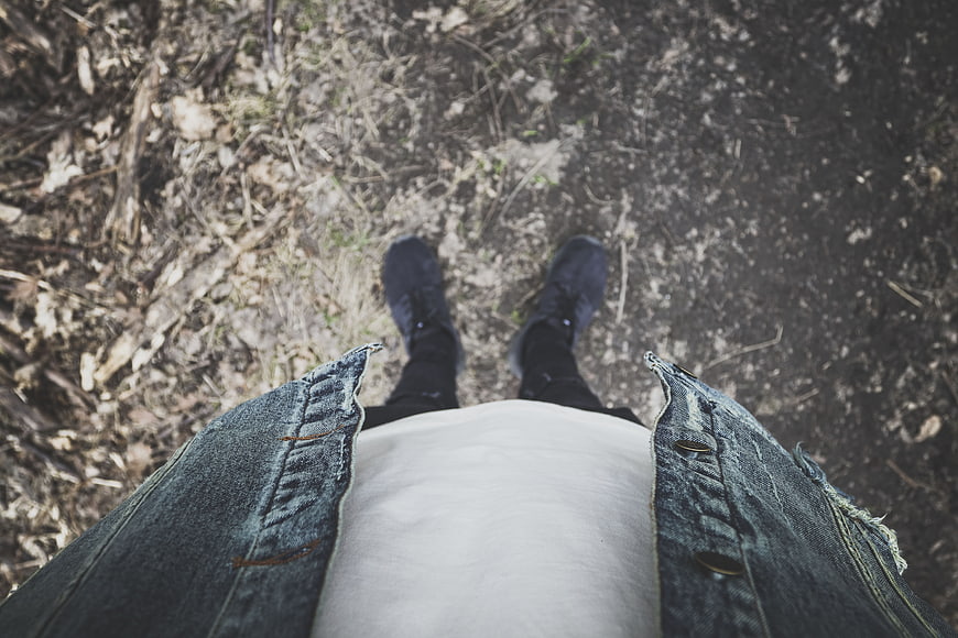 First-person view of hiking boots on forest trail