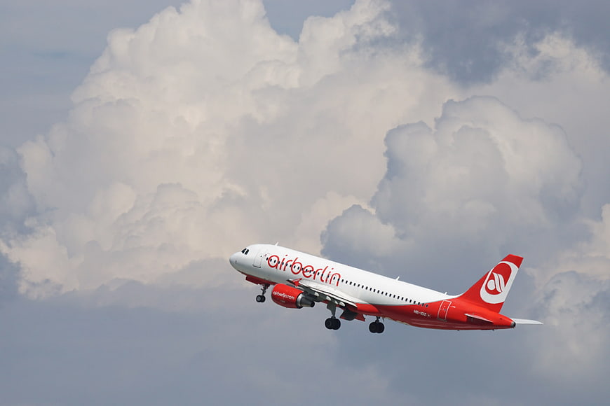 Air Berlin airplane taking off against cloudy sky