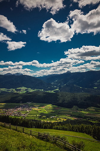 Scenic Alpine Valley with Village and Cloudy Sky