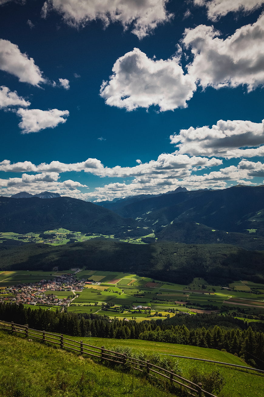 Scenic Alpine Valley with Village and Cloudy Sky
