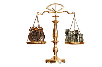Golden scales balancing vintage clock and stacks of coins