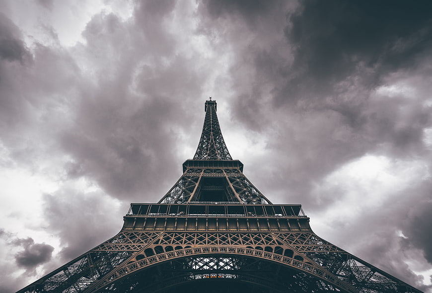 Low angle view of Eiffel Tower against dramatic cloudy sky
