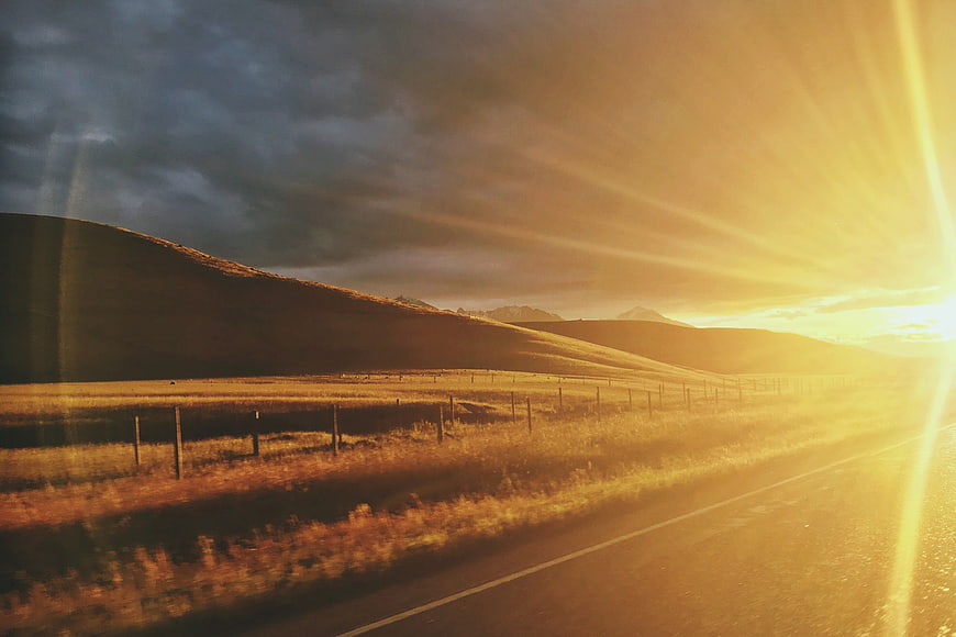 Golden Sunset Over Rolling Hills and Rural Road