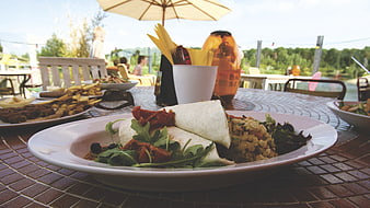 Vegetarian wrap and salad on outdoor cafe table