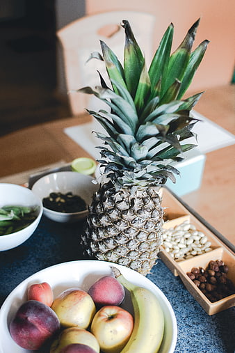 Fresh pineapple and assorted fruits on kitchen counter