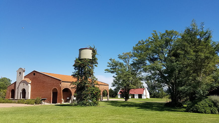 Red brick winery building with water tower and green lawn