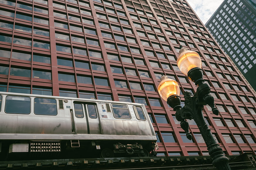 Low angle view of elevated subway train passing red brick building