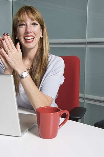 Happy Business Woman Laughing at Laptop in Office