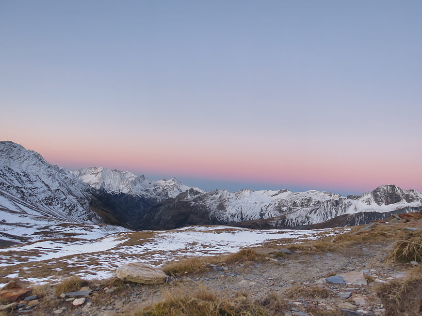 Snowy mountain range at dusk with pink and blue sky